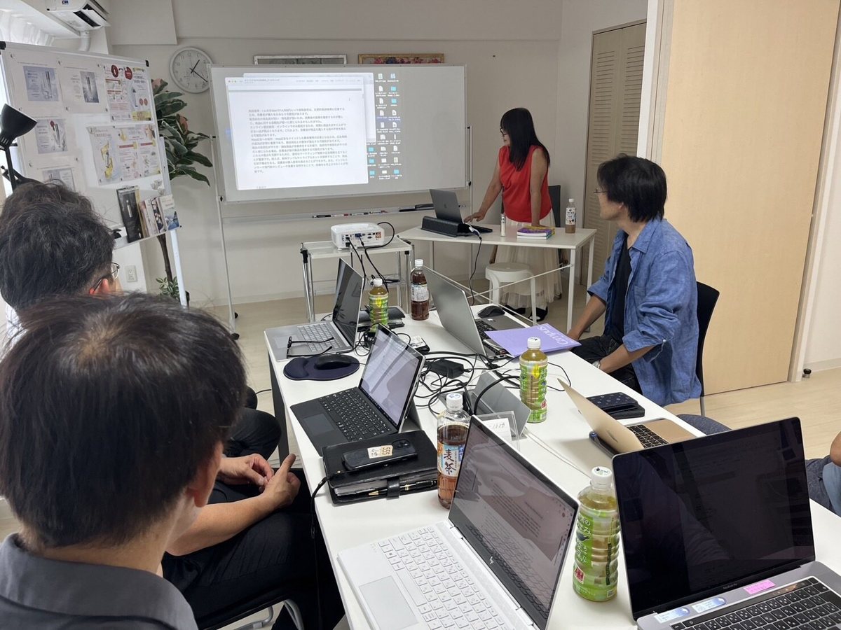 スクリーンを前に、ノートパソコンで作業する参加者
