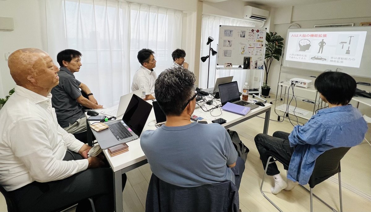 スクリーンを囲んで話を聞く参加者たち